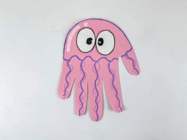 Finished pink jellyfish handprint craft on white background