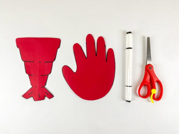 Cut red handprint and lobster tail pieces with scissors