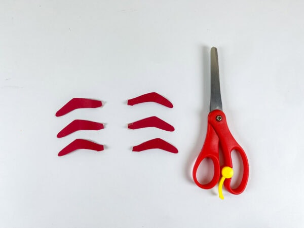 Cut red paper lobster legs laid out