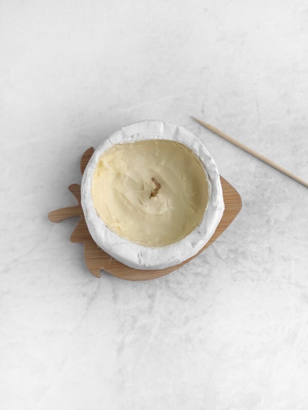 Hollowed brie wheel with melted butter inside and a wick in the center.