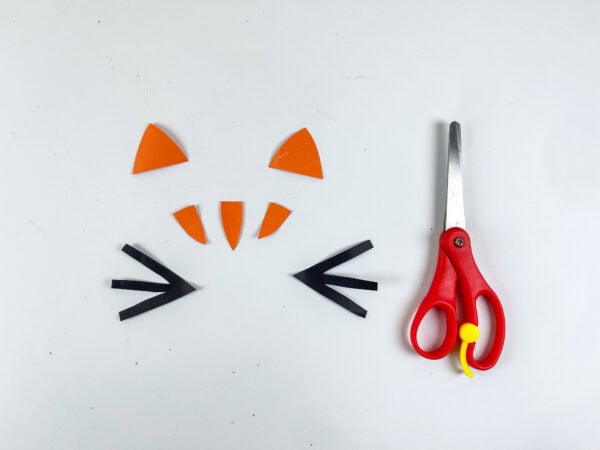 Cut paper pieces for cat ears, stripes, and whiskers