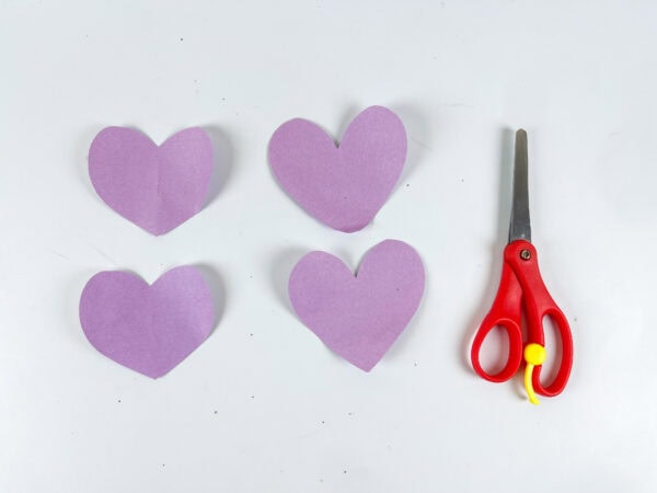 Four purple paper hearts cut out