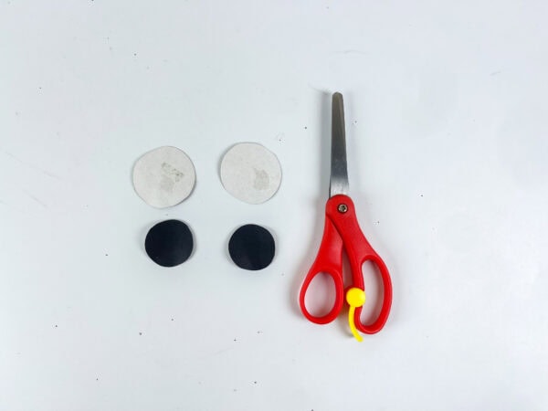 Paper circles for butterfly eyes next to scissors