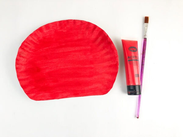 Red painted paper plate with paintbrush