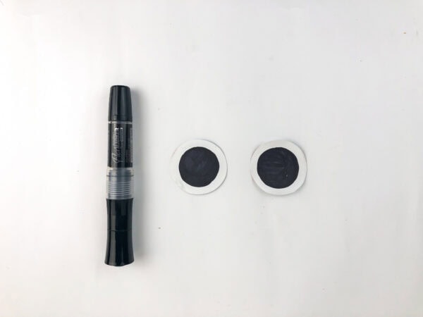 Black marker beside paper robot eyes