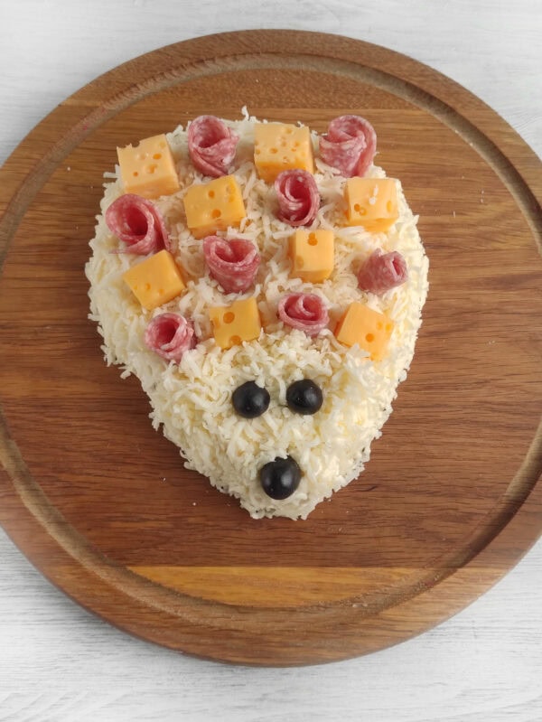 Hedgehog cheese spread face decorated with olives for eyes and nose
