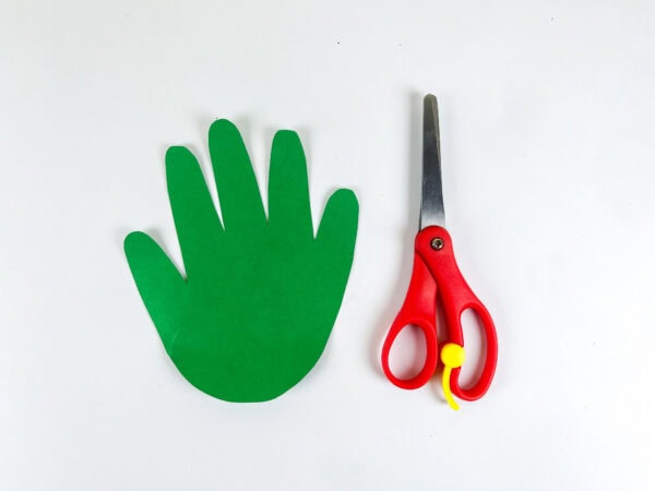 Green handprint cutout beside scissors