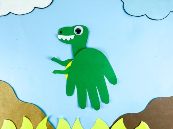 Tyrannosaurus handprint craft on blue background scene
