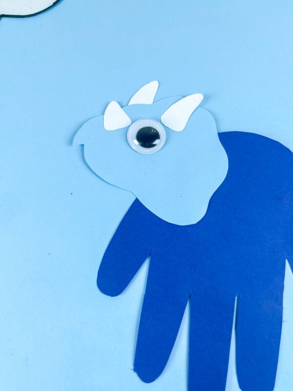 Close up of triceratops handprint craft head with horns and googly eye