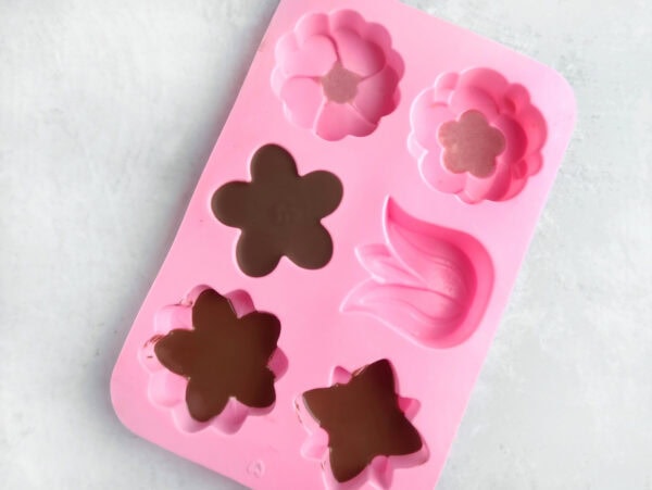 Melted chocolate poured into flower-shaped silicone mold