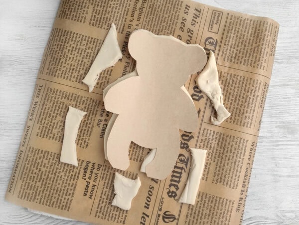 Dough pieces arranged to form teddy bear shape
