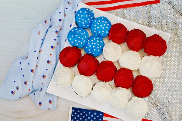 Patriotic flag cupcakes arranged on white tray