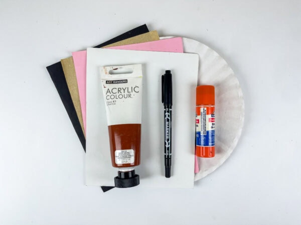 Craft supplies with paper plate, paint, marker, and glue