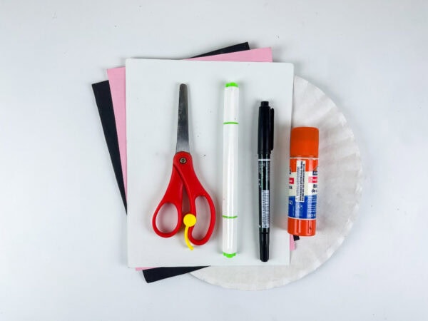 Craft supplies with scissors, markers, glue, and paper plate
