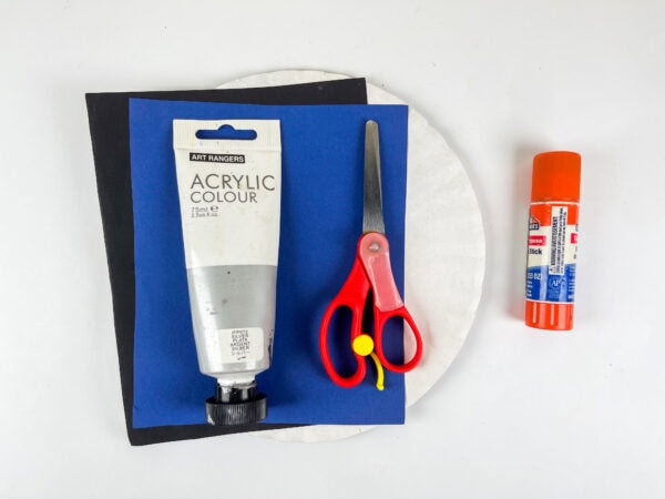 Craft supplies with paper plate, paint, scissors, glue, and paper