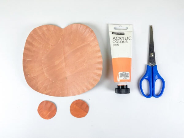 Paper plate painted peach with ear pieces cut out