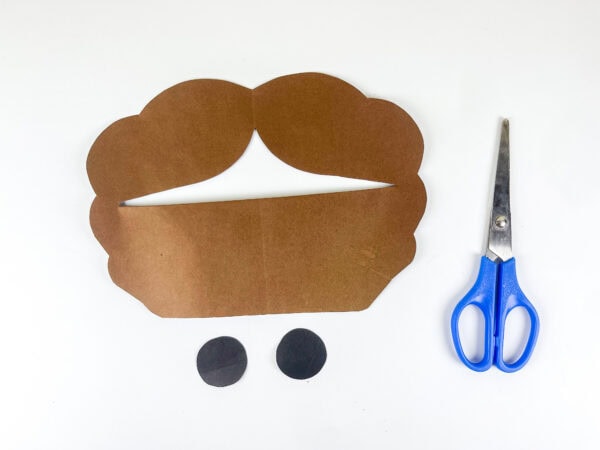 Brown hair piece and eye circles cut from paper