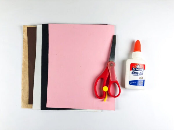 Construction paper sheets scissors and glue for cow handprint craft supplies