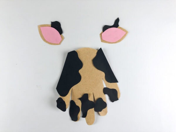 Cow handprint base with spots attached and ears positioned above