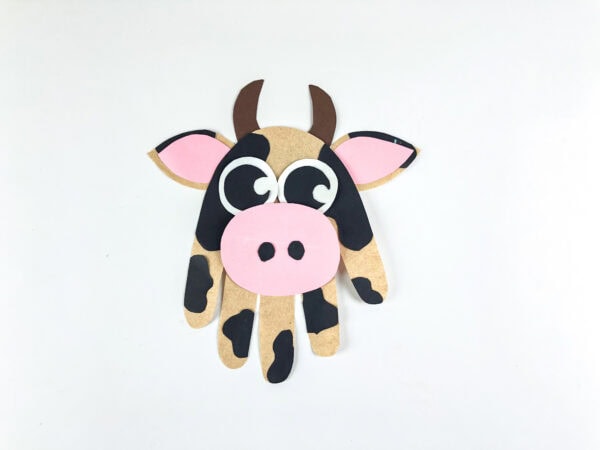 Finished cow handprint craft on white background