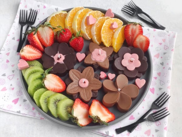 Chocolate flower candles arranged with strawberries, oranges, and kiwi