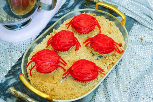 Finished crab cupcakes arranged on crumb “sand” display tray