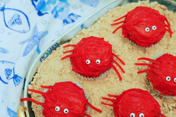 Close-up of red crab cupcakes with candy eyes on crumb base