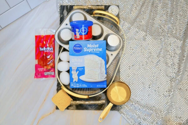 Cake mix, frosting, Twizzlers, and baking supplies on tray