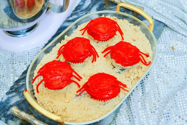 Frosted red crab cupcakes placed on graham cracker crumbs