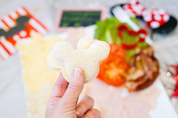 Hand holding Mickey-shaped sandwich bread cutout