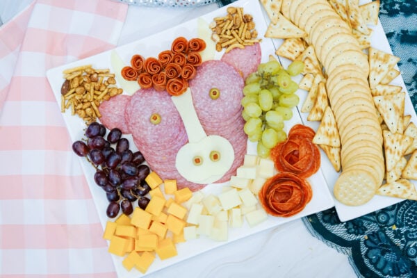 Highland cow charcuterie board with crackers, grapes, and cheese