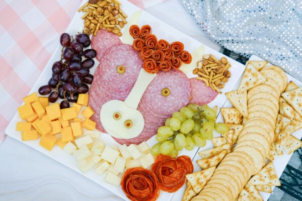 Highland cow snack tray with salami, crackers, and fruit