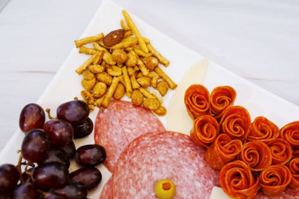 Snack mix and grapes beside a highland cow charcuterie board