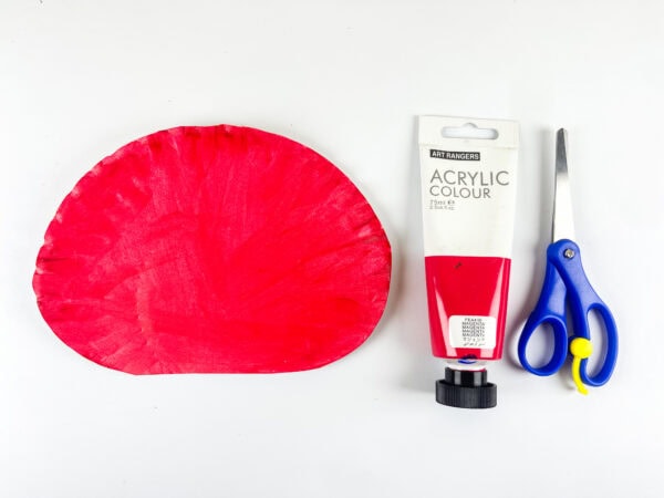 Painted red paper plate with scissors and paint