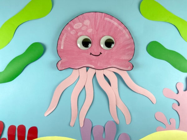 Pink jellyfish paper plate craft on blue background