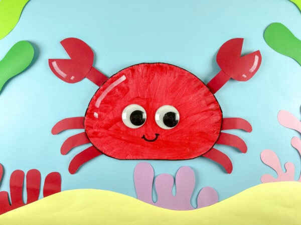 Red paper plate crab craft on ocean background