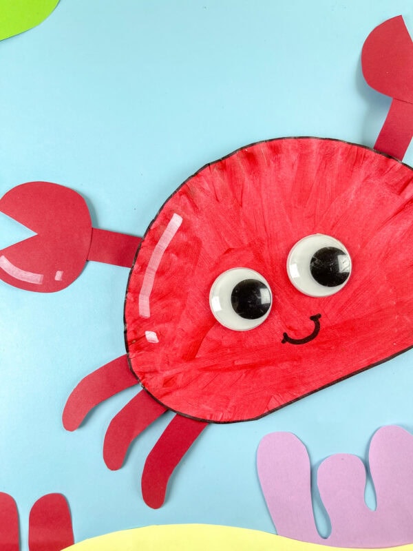 Close-up of smiling crab craft on blue background