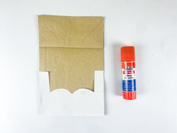 Paper bag base with face outline and glue stick