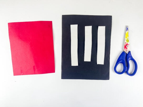 Red paper and white strip cutouts for hat section
