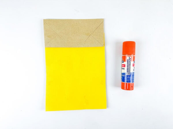 Yellow paper bag with glue stick for craft base
