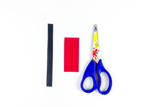 Black strip, red paper, and scissors