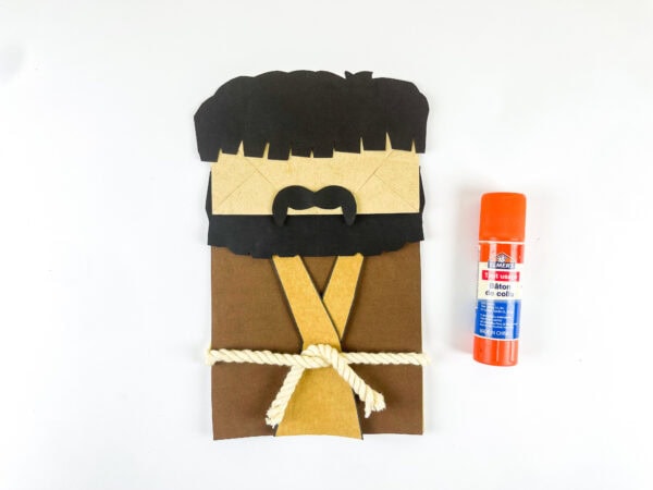 Attach hair, beard, and mustache to paper bag