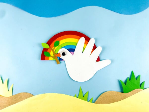 Finished dove handprint craft with rainbow background