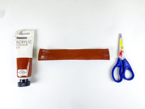 Painted brown belt strip with scissors and paint