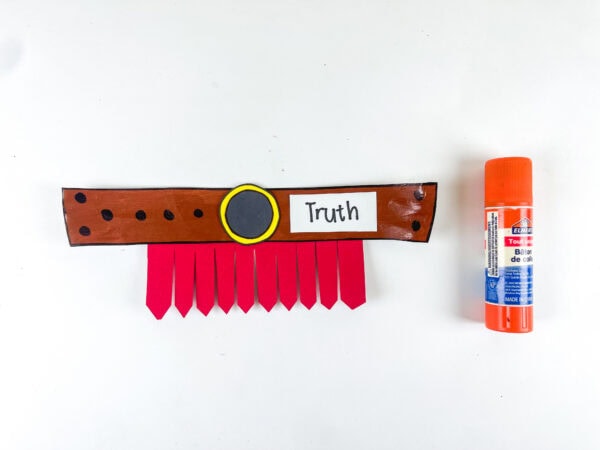 Completed truth belt craft with label beside glue stick.
