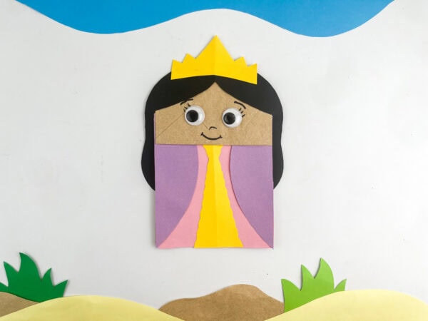  Finished Queen Esther paper bag puppet displayed against a desert-themed background