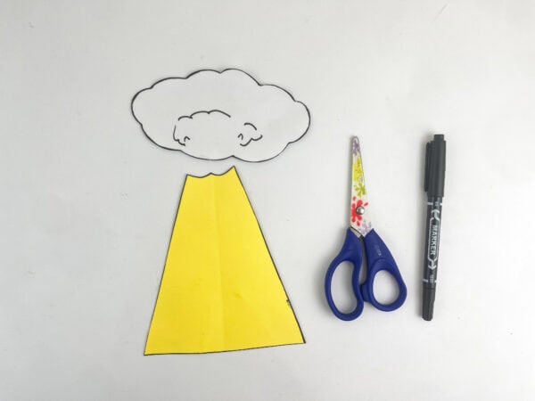 Cutout paper shapes of a cloud and a yellow beam of light next to scissors and a black marker.