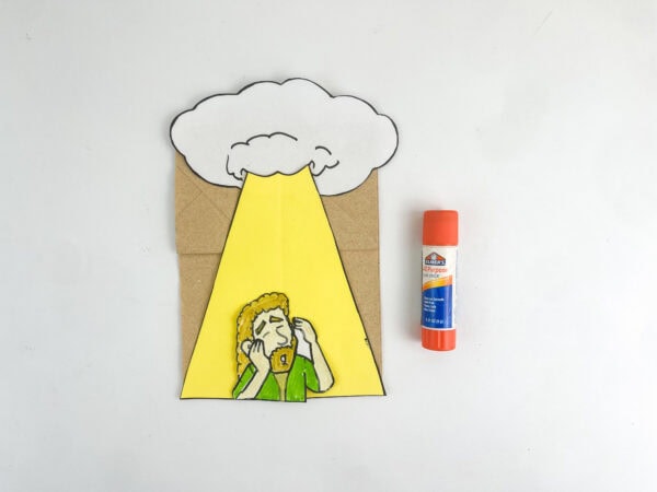 Completed Saul conversion paper bag craft resting next to an orange glue stick.