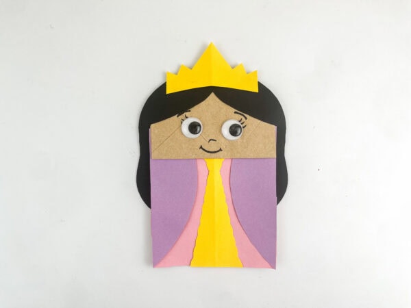 Completed Queen Esther paper bag puppet with face, hair, dress, and crown