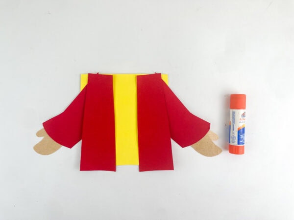 Attach yellow tunic behind robe